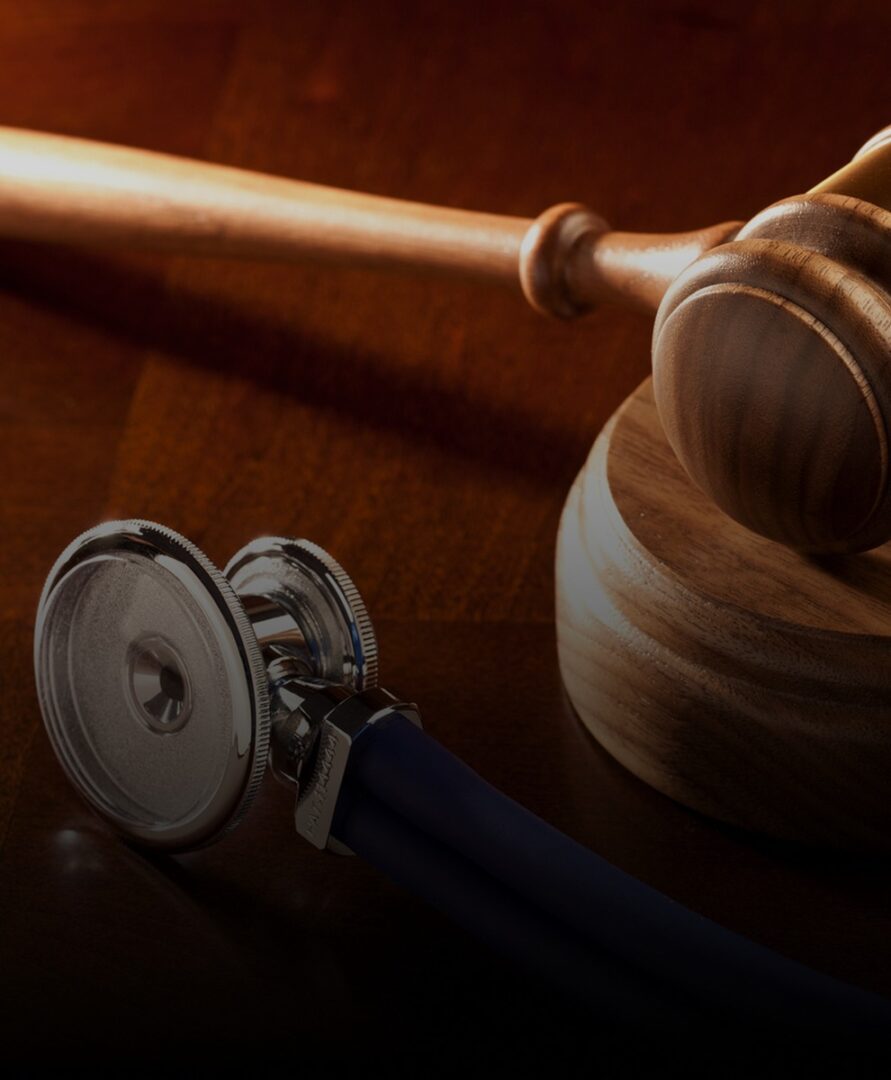 Gavel and stethoscope on wooden surface.